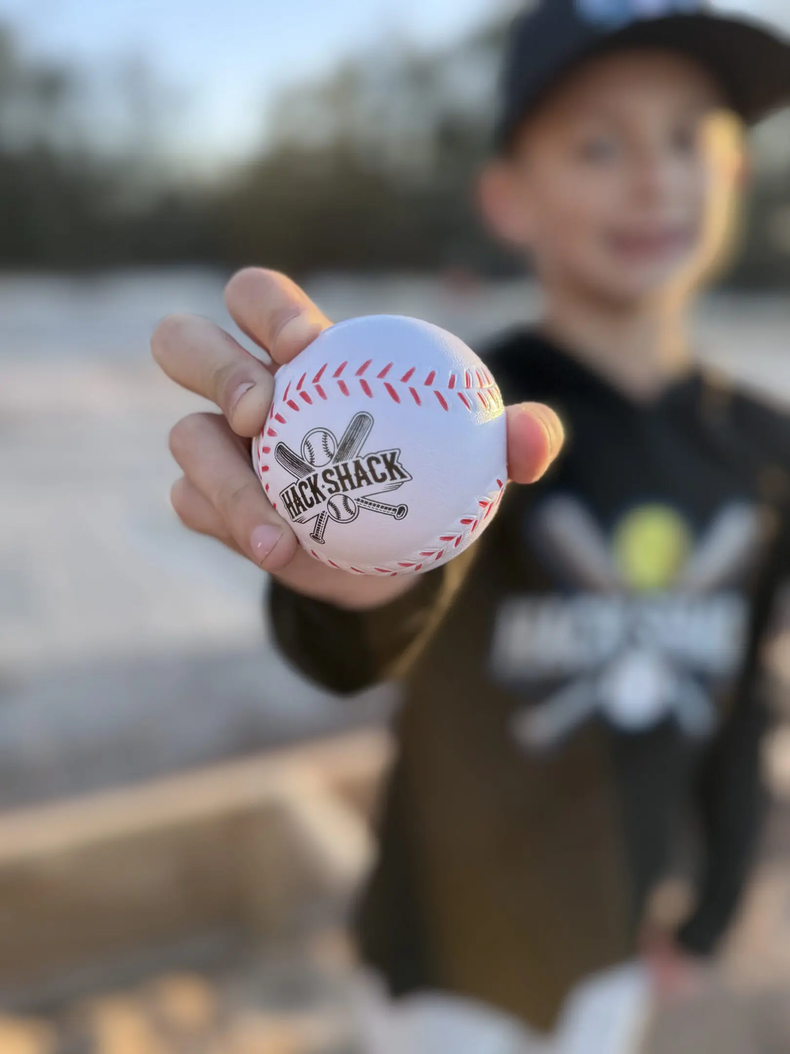Close-up of boy holding baseball with logo