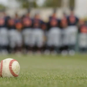 Baseball on grass with blurred team in background