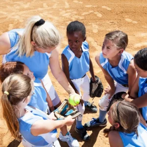 Girls' softball team huddle with coach